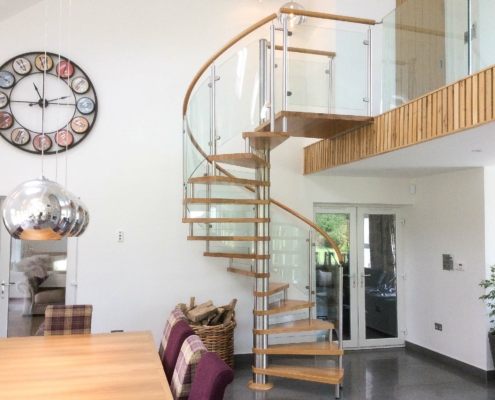 large oak spiral stair in a house with a huge wall clock