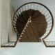 top view of triangular platform of a spiral staircase in dark wood
