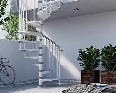 white outdoor spiral stair running up side of white rendered house