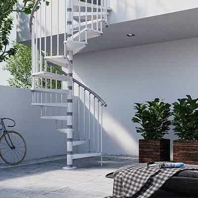 white outdoor spiral stair running up side of white rendered house