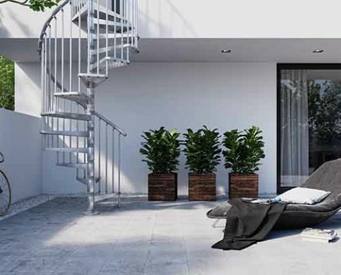 Exterior-Zink-Spiral-Staircase running up the side of a house with sun lounger on patio