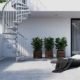 Exterior-Zink-Spiral-Staircase running up the side of a house with sun lounger on patio