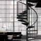 slimline black spiral staircase in from of a huge crittall window