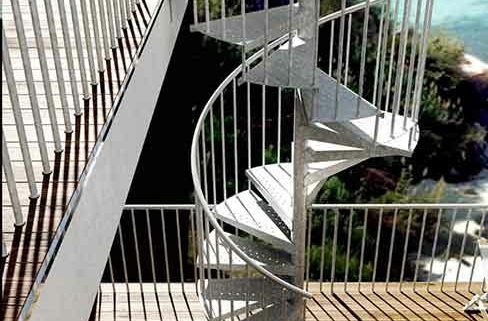 side view of galvanised spiral staircase outside infront of the ocean