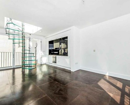 crisp internal room in a house with dark timber flooring and white walls featuring a glass spiral staircase