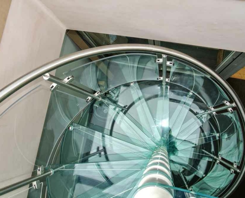 image looking down on a glass spiral stair with stainless handrail