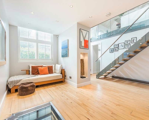 Hallway with glass floor partly visible, wooden floor and modern stair in background