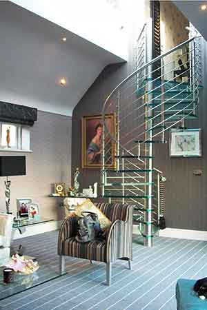 conventional sitting room with a glass spiral staircase. Sofa in foreground