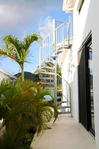 external spiral staircase with blue sky and palm trees