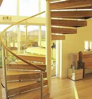 spiral stair with wooden steps and large window behind