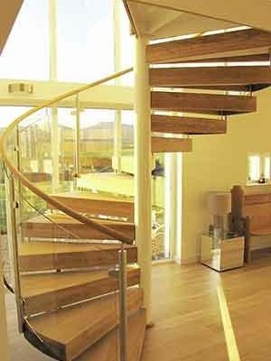 spiral stair with wooden steps and large window behind