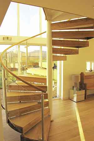 spiral stair with wooden steps and large window behind