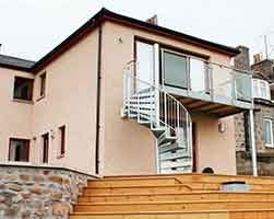 external spiral stair with a balcony to the rear of a house