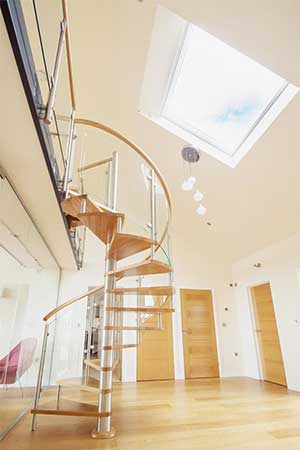 oak step spiral with curved glass. Large roof window above