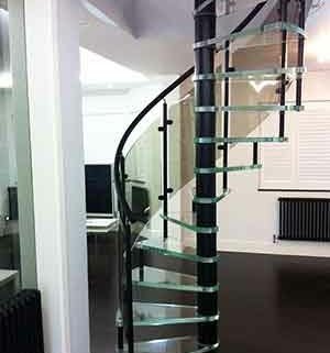 white and black living area with spiral staircase with glass treads in middle