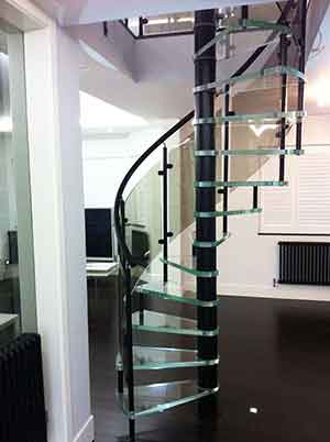 white and black living area with spiral staircase with glass treads in middle