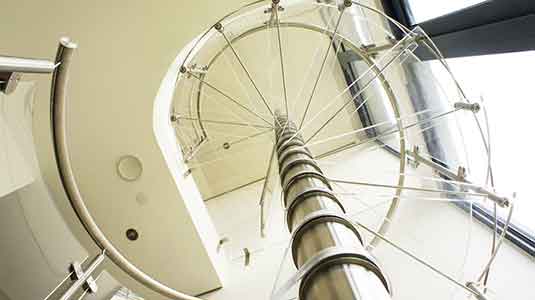 view looking up through acrylic steps of a spiral staircase