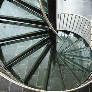 plan look at a glass spiral staircase with a black tiled floor below