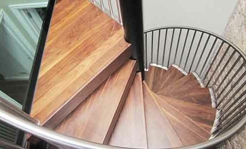 spiral stair with walnut steps with a glass platform above