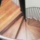 spiral stair with walnut steps with a glass platform above