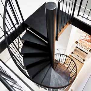 small spiral stair in black leading to a loft space