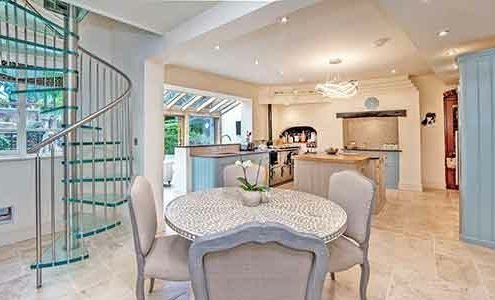 living space with table to centre, kitchen to background and glass spiral to left of picture