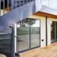 outside spiral staircase dark grey in foreground wooden decking behind