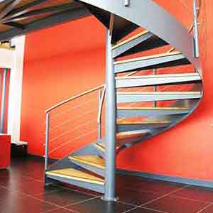 large red wall with a light gray spiral stair in front