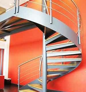 large red wall and steel and oak spiral stair in foreground