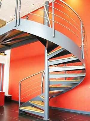 large red wall and steel and oak spiral stair in foreground