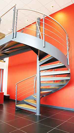 large red wall and steel and oak spiral stair in foreground