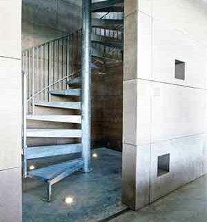 internal silver spiral stair in steel with blank walls around