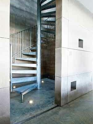 internal silver spiral stair in steel with blank walls around