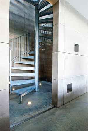 internal silver spiral stair in steel with blank walls around