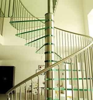 large spiral staircase with stainless steel and glass in a living space