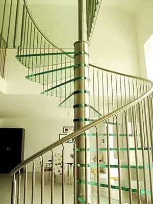 large spiral staircase with stainless steel and glass in a living space