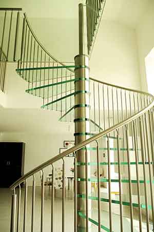 large spiral staircase with stainless steel and glass in a living space