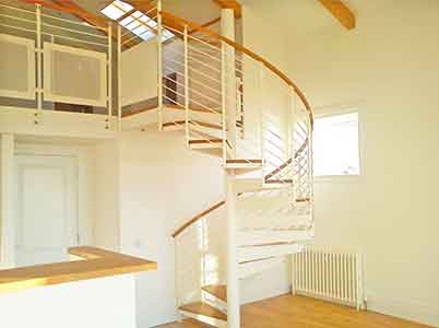 spiral stair in an apartment rising to a mezzanine