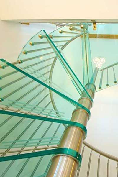 View from the underside of a green glass step spiral staircase