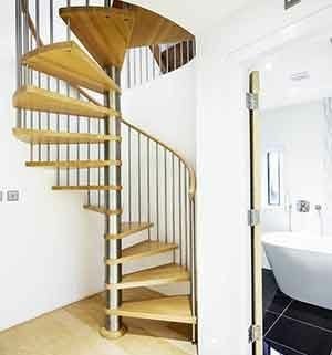 spiral stair set in front of a curved wall with bathroom to right