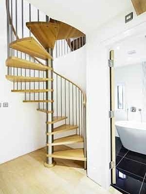 spiral stair set in front of a curved wall with bathroom to right