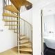 spiral stair set in front of a curved wall with bathroom to right