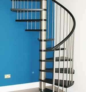 stainless steel and black spiral staircase with a bright blue wall behind