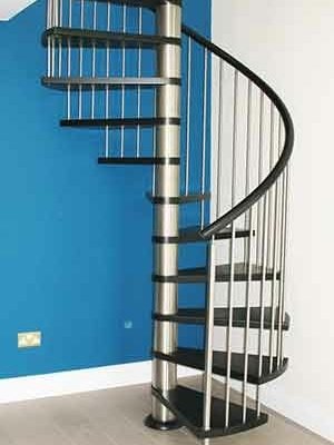 stainless steel and black spiral staircase with a bright blue wall behind