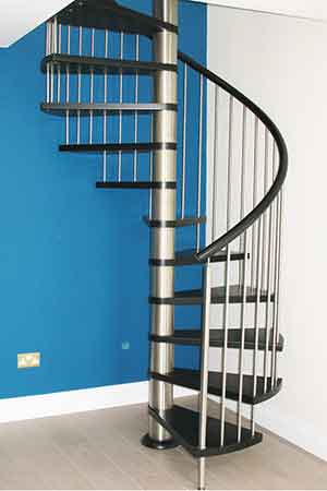 stainless steel and black spiral staircase with a bright blue wall behind