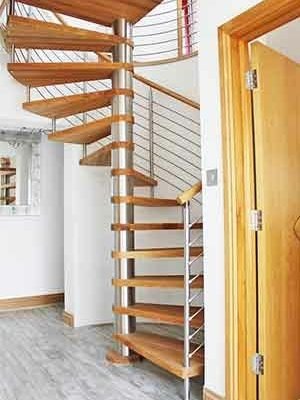 oak spiral stair in a house with a tiled floor and curved wall behind