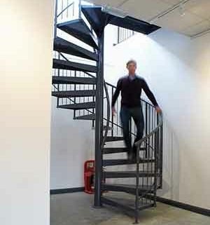 dark grey spiral stair with a man walking down