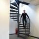 dark grey spiral stair with a man walking down