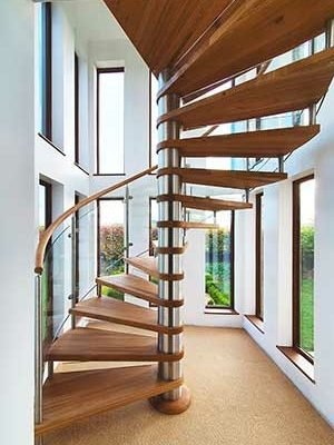 stunning spiral stair in a house with windows behind