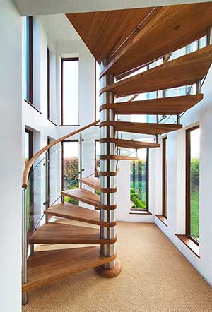 stunning spiral stair in a house with windows behind